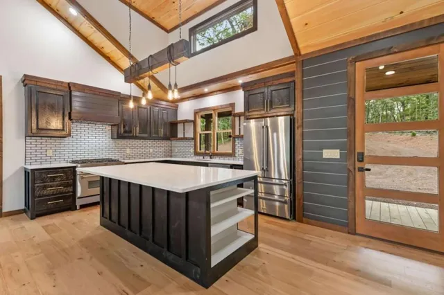 a view of kitchen with stainless steel appliances granite countertop a stove and a refrigerator