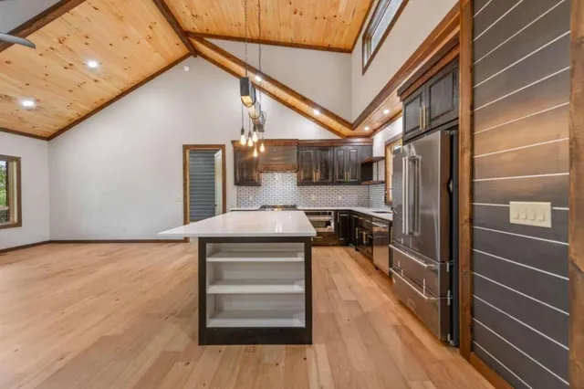 a kitchen with a refrigerator and wooden floor