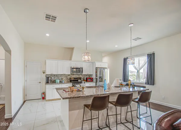 a spacious bathroom with a double vanity sink a mirror and a toilet