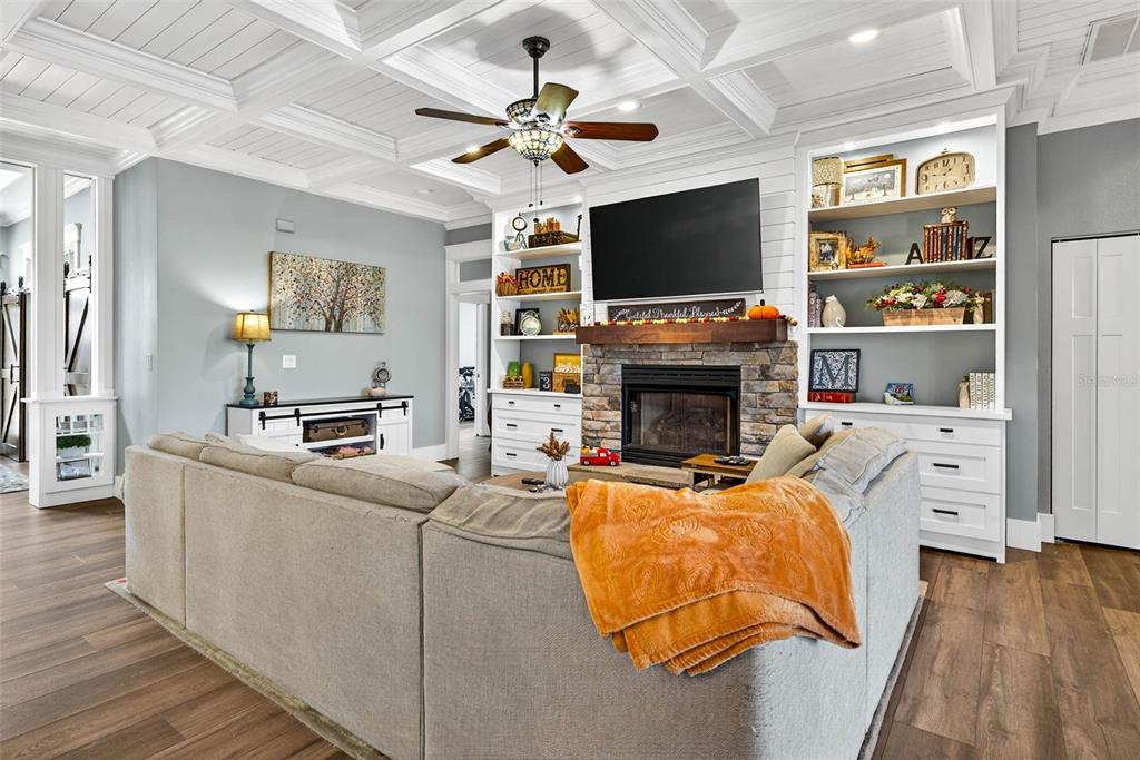 18051 Hancock Bluff Road Dade City, FL 33523 - Photo 22 of 98 a living room with furniture a flat screen tv and a fireplace