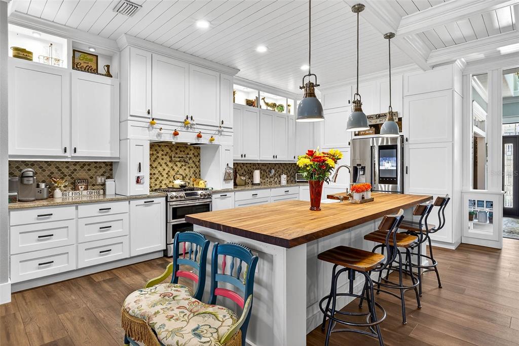 18051 Hancock Bluff Road Dade City, FL 33523 - Photo 30 of 98 a kitchen with stainless steel appliances kitchen island granite countertop a table chairs in it and wooden floors