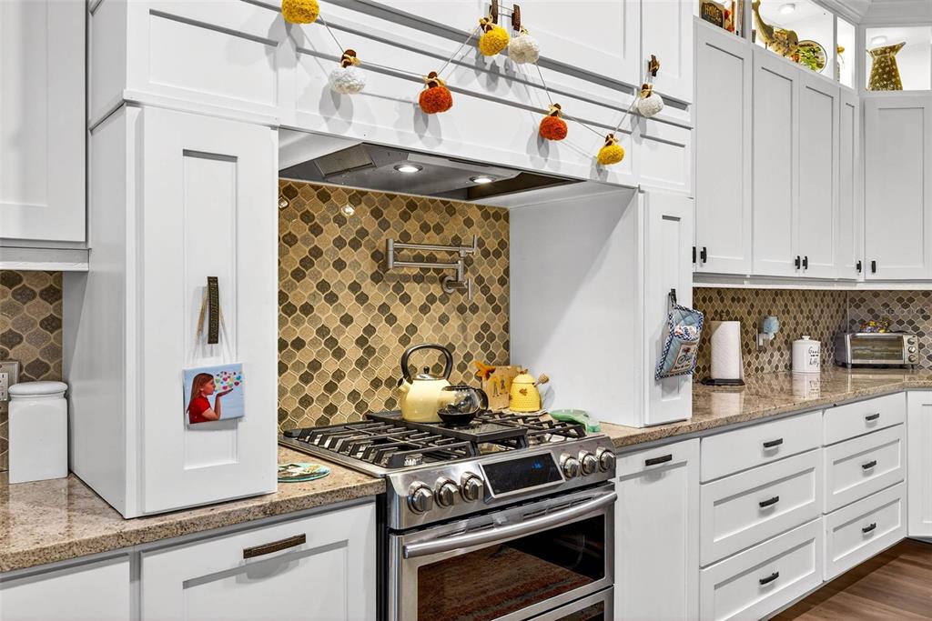 18051 Hancock Bluff Road Dade City, FL 33523 - Photo 34 of 98 a kitchen with granite countertop white cabinets and white appliances