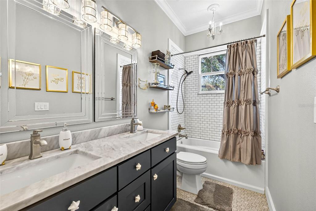 18051 Hancock Bluff Road Dade City, FL 33523 - Photo 45 of 98 a bathroom with a granite countertop sink toilet a mirror and shower