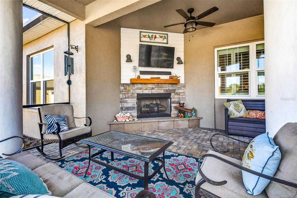 18051 Hancock Bluff Road Dade City, FL 33523 - Photo 63 of 98 a living room with furniture a flat screen tv and a fireplace