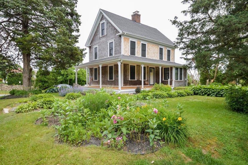 a front view of a house with a yard and potted plants