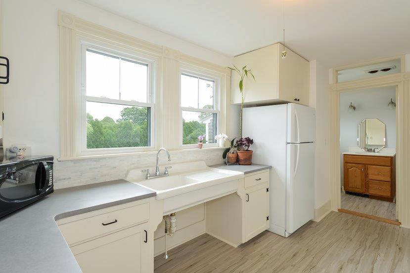 32 Fairhaven Road Mattapoisett, MA 02739 - Photo 4 of 11 a kitchen with a sink a refrigerator a stove and white cabinets with wooden floor