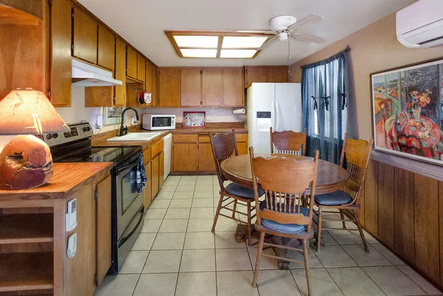 a kitchen with stainless steel appliances a stove a refrigerator a dining table and chairs