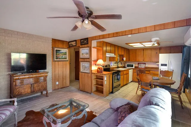 a living room with furniture kitchen view and a flat screen tv