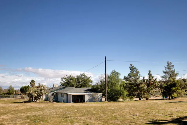 a front view of a house with a yard and mountain view
