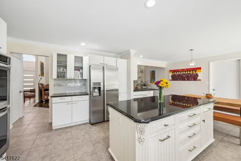 a kitchen with stainless steel appliances granite countertop a sink and a refrigerator