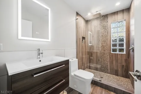 a bathroom with a sink a toilet a glass door and shower