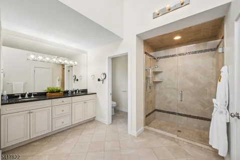 a bathroom with a granite countertop sink a mirror and a shower