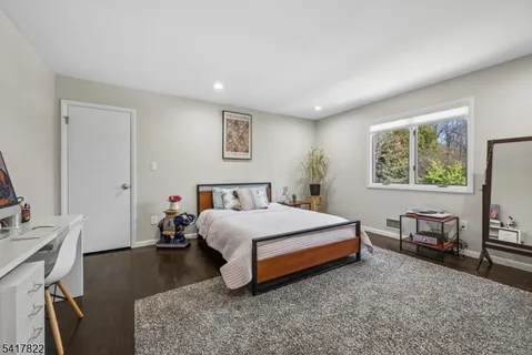 a spacious bedroom with a bed and a flat screen tv