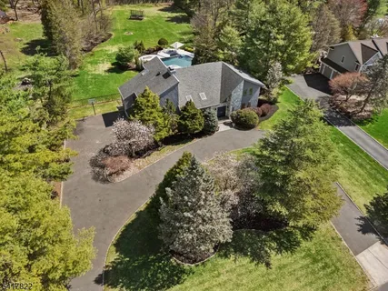 an aerial view of a house with a yard and lake