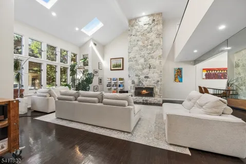 a living room with fireplace furniture and a large window