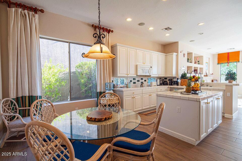 2347 West River Rock Court Phoenix, AZ 85086 - Photo 4 of 25 a kitchen with stainless steel appliances kitchen island granite countertop a stove a sink a dining table and chairs