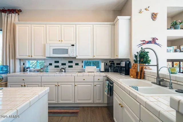 a kitchen with kitchen island white cabinets and white appliances