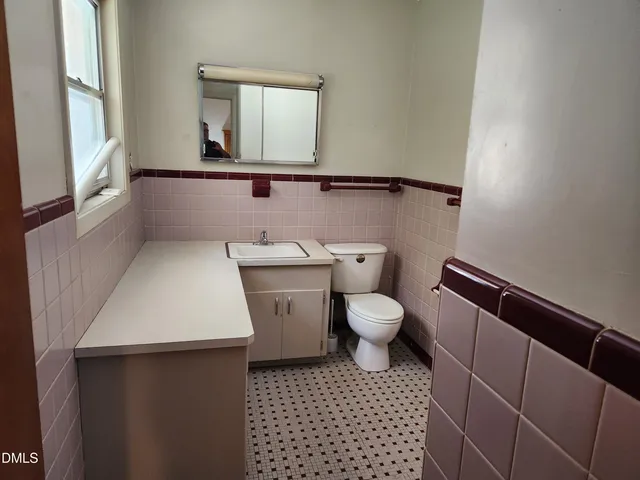 a bathroom with a toilet a sink and a window