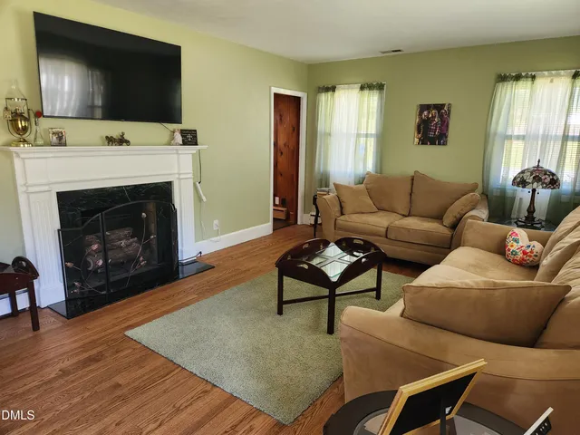 a living room with furniture a flat screen tv and a fireplace