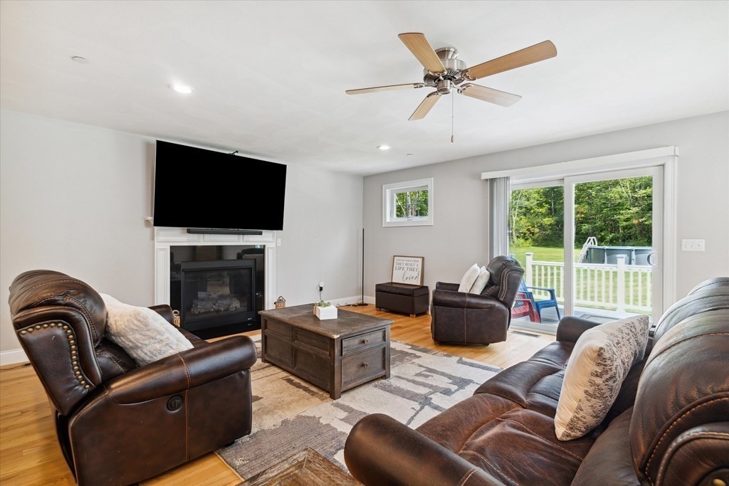 54 Lane Road Derry, NH 03038 - Photo 11 of 34 a living room with furniture a flat screen tv and a fireplace