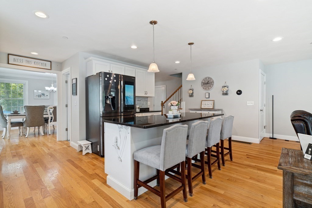 54 Lane Road Derry, NH 03038 - Photo 6 of 34 a kitchen with stainless steel appliances kitchen island granite countertop a dining table chairs and a refrigerator