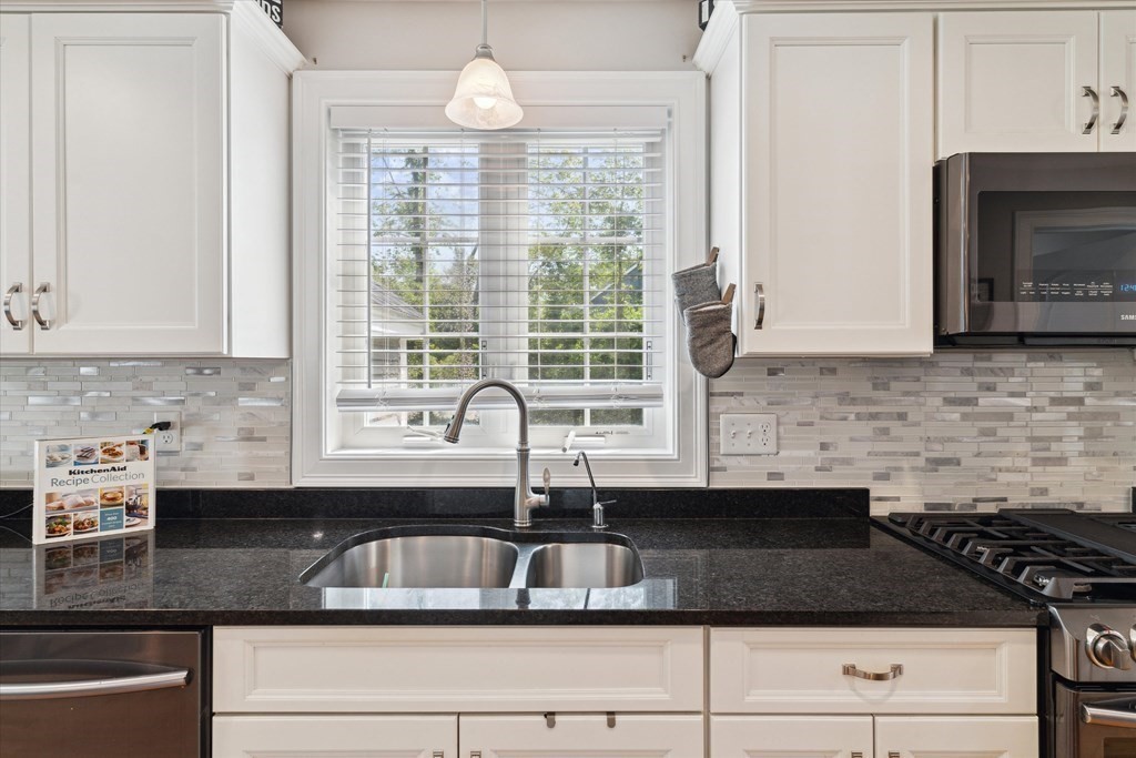 54 Lane Road Derry, NH 03038 - Photo 7 of 34 a kitchen with granite countertop a sink a stove and cabinets