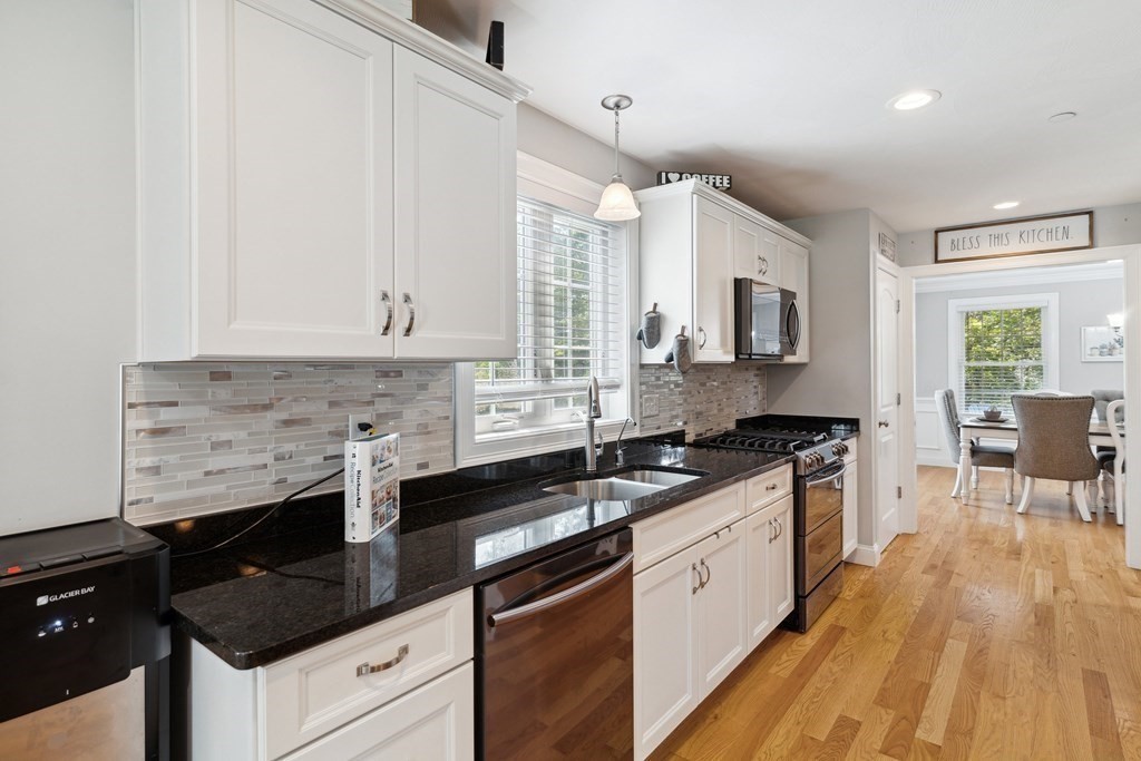 54 Lane Road Derry, NH 03038 - Photo 8 of 34 a kitchen with granite countertop a sink a stove and cabinets