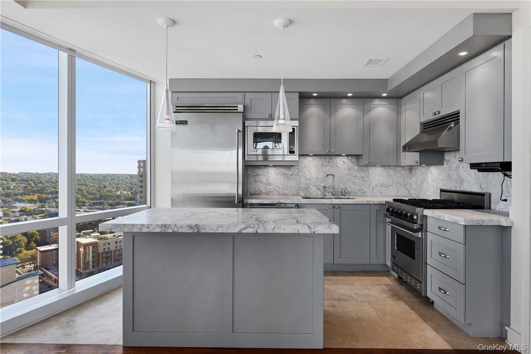 1 Renaissance Square, Unit V4G White Plains, NY 10601 - Photo 4 of 17 a kitchen with stainless steel appliances granite countertop a sink a stove and a refrigerator