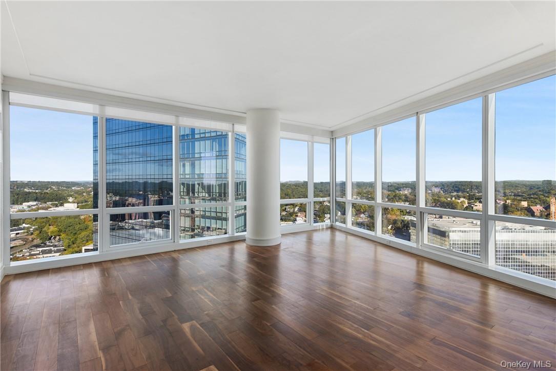 1 Renaissance Square, Unit V4G White Plains, NY 10601 - Photo 7 of 17 an empty room with wooden floor and large windows