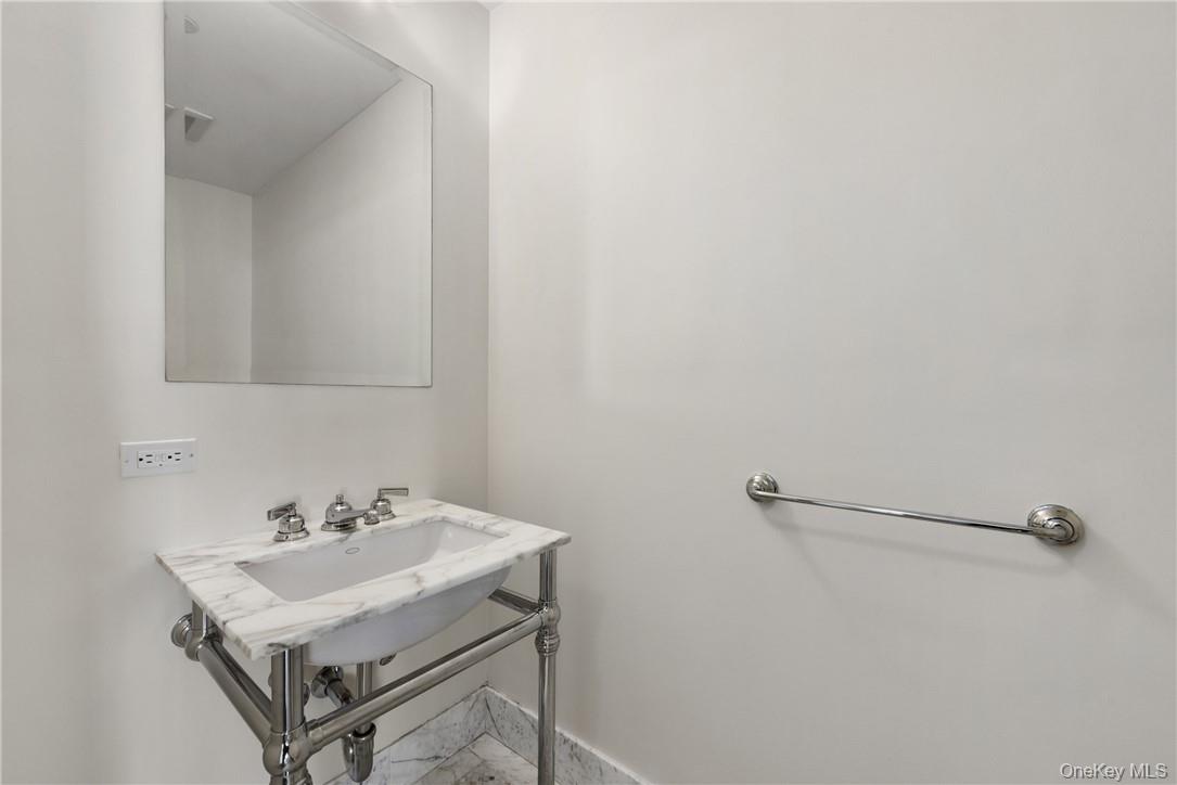 1 Renaissance Square, Unit V4G White Plains, NY 10601 - Photo 8 of 17 a white sink sitting under a bathroom mirror