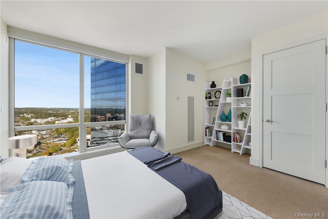 1 Renaissance Square, Unit V4G White Plains, NY 10601 - Photo 9 of 17 a bedroom with a bed and a view of kitchen