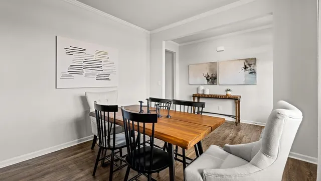 a open kitchen with stainless steel appliances kitchen island granite countertop a stove a sink a refrigerator and white cabinets with wooden floor