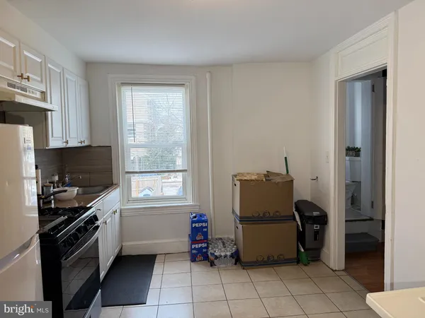 a kitchen with a refrigerator and a stove top oven