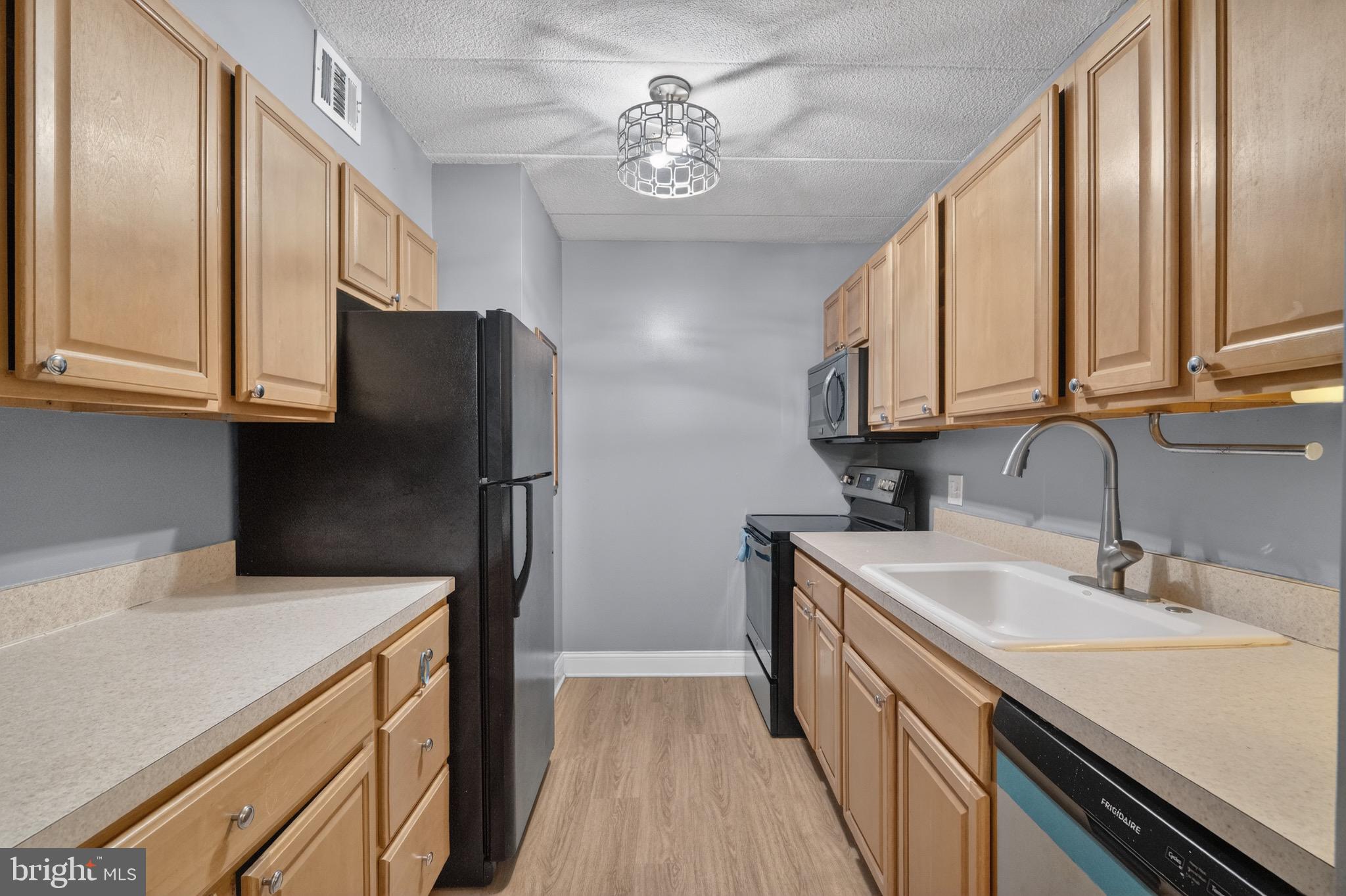 3301 Hewitt Avenue, Unit 403 Silver Spring, MD 20906 - Photo 5 of 19 Modern kitchen with warm wood cabinetry.