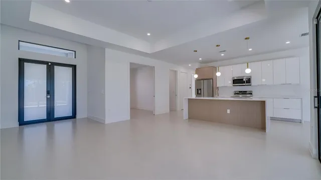 a view of kitchen with kitchen island stainless steel appliances sink and refrigerator