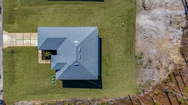 a aerial view of a house with swimming pool lawn chairs and a yard