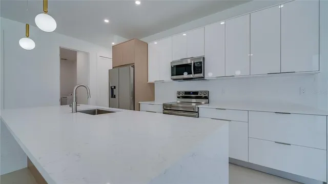 a kitchen with stainless steel appliances granite countertop a sink stove and refrigerator