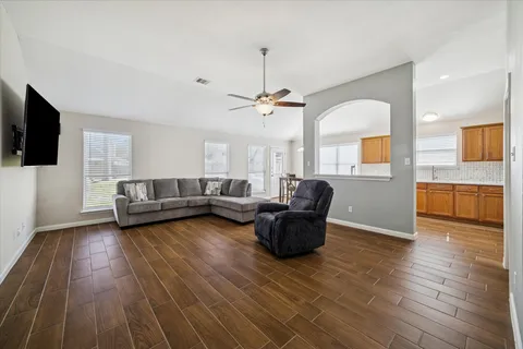 a living room with furniture and a wooden floor