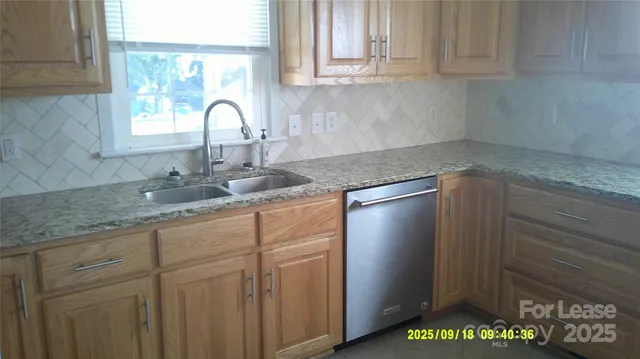 a kitchen with granite countertop white cabinets and a sink