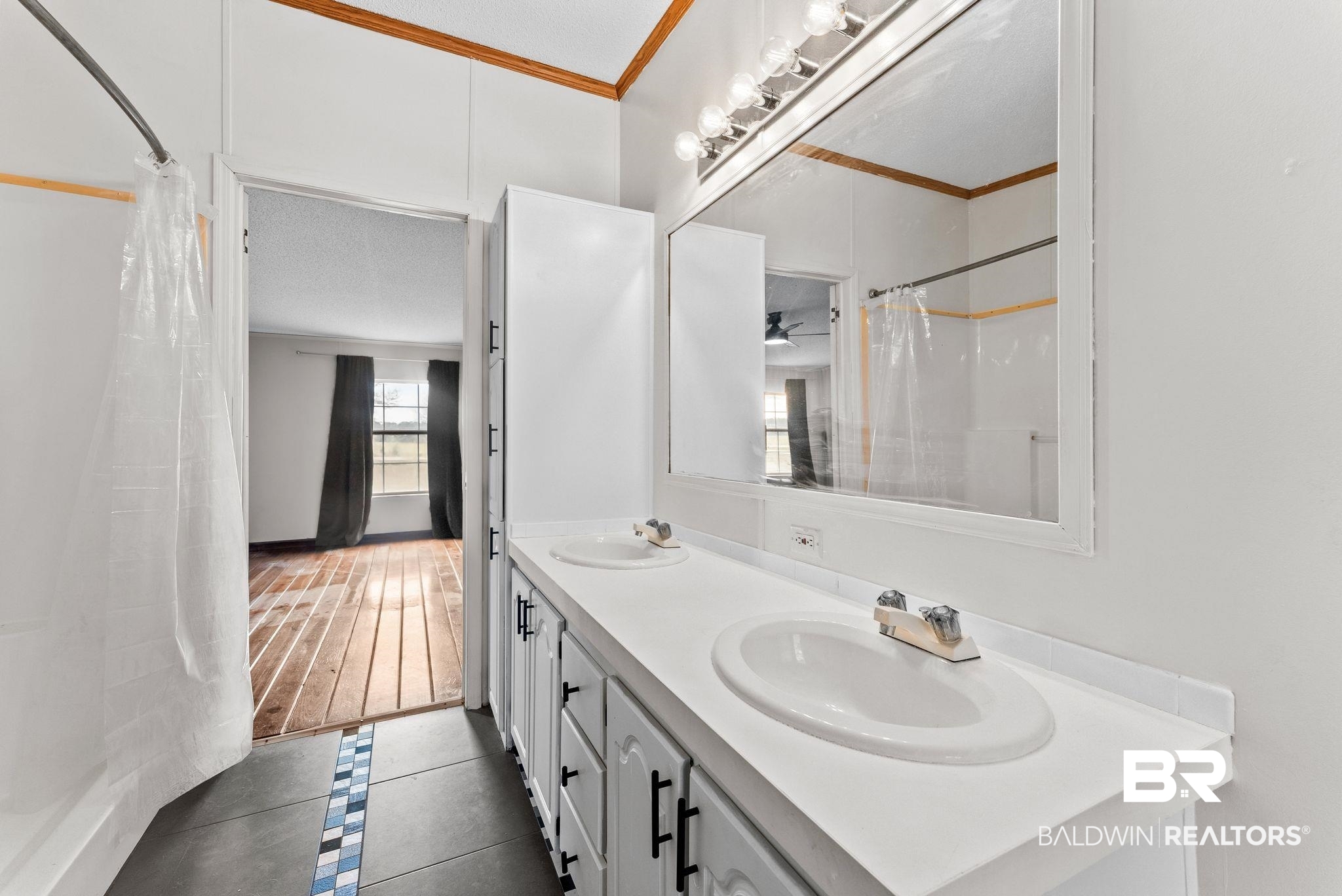 34904 Pine Road South Stapleton, AL 36578 - Photo 23 of 42 Full bath with double vanity, curtained shower, crown molding, dark tile patterned floors, and inlaid floor details