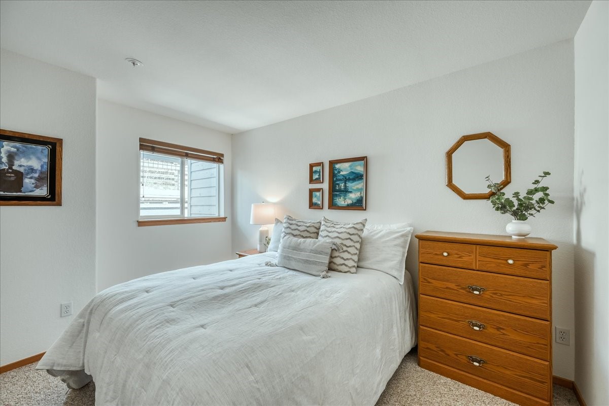 91399 Ryan Gulch Road, Unit B6 Silverthorne, CO 80498 - Photo 13 of 36 a bedroom with a bed a dresser and window