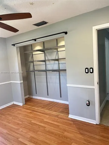 an empty room with wooden floor and cabinet