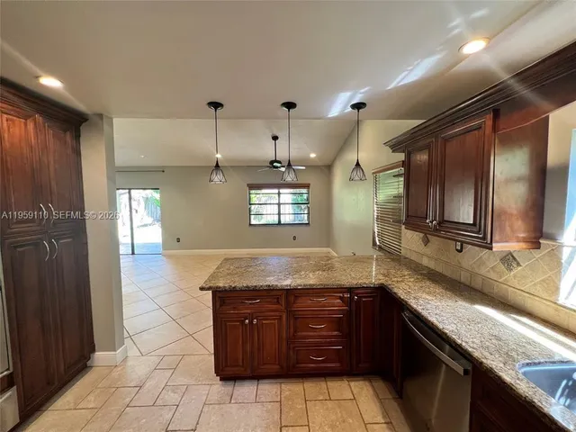 a kitchen with granite countertop a sink and cabinets