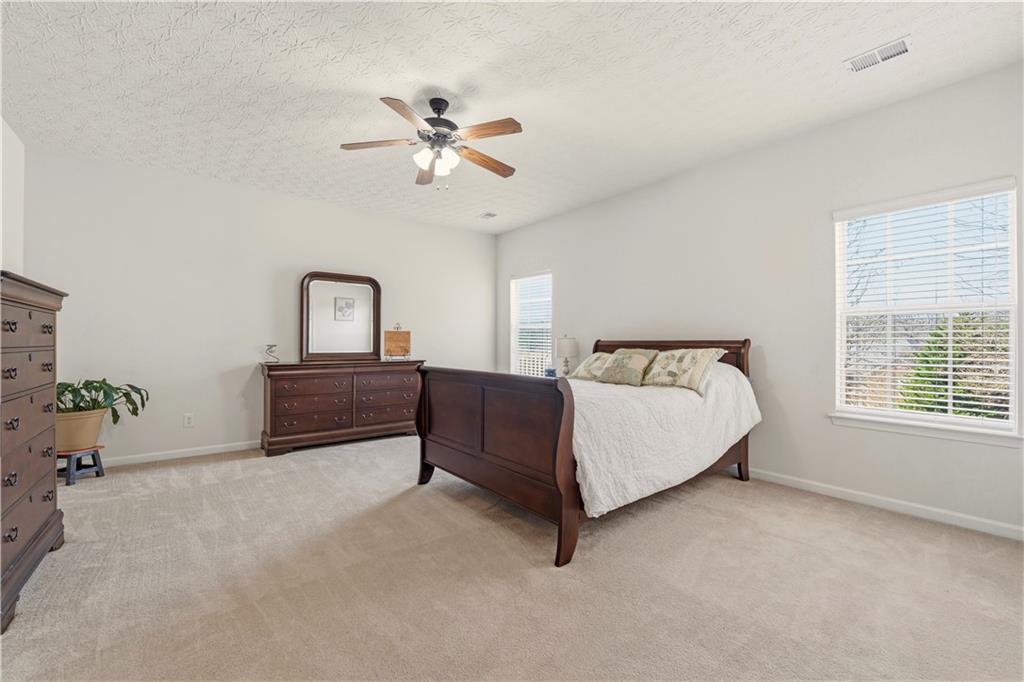 2708 Oakmont Way Monroe, GA 30656 - Photo 14 of 40 a spacious bedroom with a bed dresser and a window