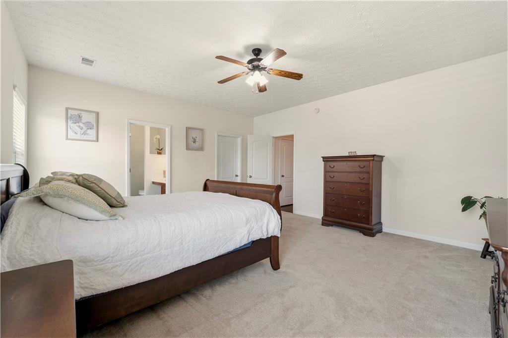 2708 Oakmont Way Monroe, GA 30656 - Photo 15 of 40 a bedroom with a large bed and ceiling fan