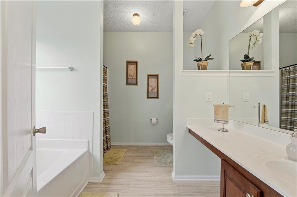 2708 Oakmont Way Monroe, GA 30656 - Photo 16 of 40 a bathroom with a tub sink and mirror