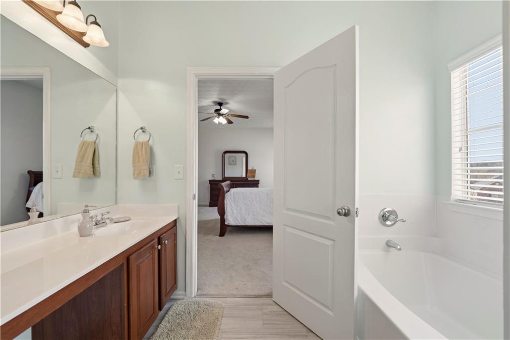 2708 Oakmont Way Monroe, GA 30656 - Photo 17 of 40 a en suite bathroom with a tub double vanity and a mirror