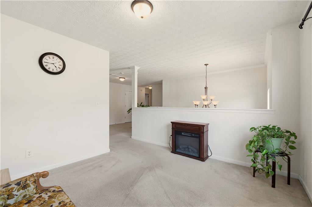 2708 Oakmont Way Monroe, GA 30656 - Photo 20 of 40 a view of a livingroom with a fireplace a sink and a chandelier