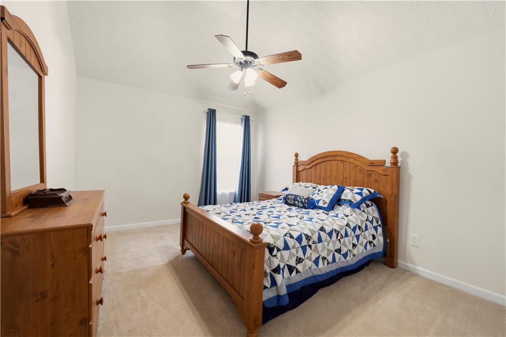 2708 Oakmont Way Monroe, GA 30656 - Photo 29 of 40 a bedroom with a bed and a chandelier