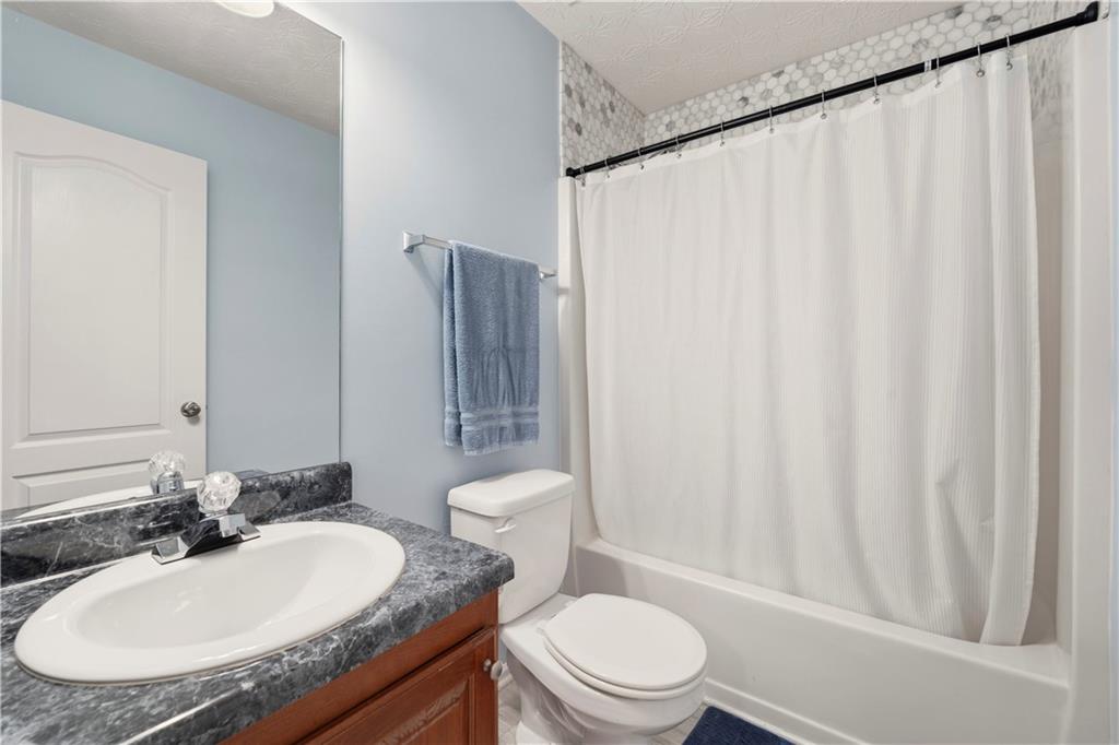 2708 Oakmont Way Monroe, GA 30656 - Photo 30 of 40 a bathroom with a granite countertop sink toilet and a mirror